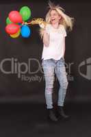 Junge lachende Frau mit Luftballone in der Hand