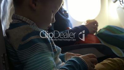 Little child in plane using smartphone