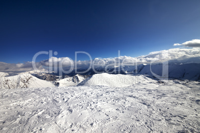 Wide-angle view on off-piste slope and snowy mountains
