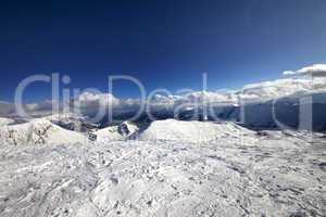 Wide-angle view on off-piste slope and snowy mountains