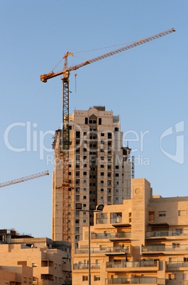 Lifting crane and building under construction  at sunset