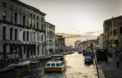 Ancient buildings and boats in the channel in Venice