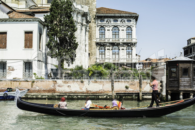 Ancient buildings and boats in the channel in Venice.