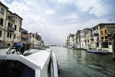 Ancient buildings and boats in the channel in Venice