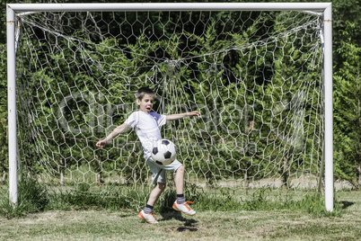 Child playing football in a stadium