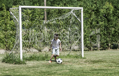 Child playing football in a stadium