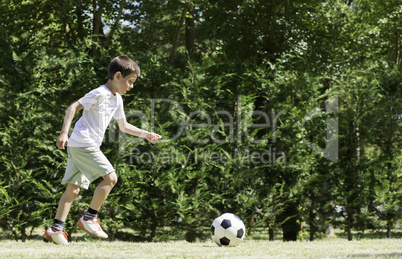 Child playing football in a stadium