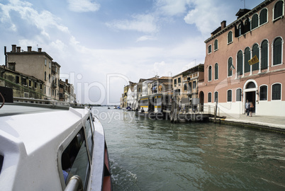 Ancient buildings and boats in the channel in Venice