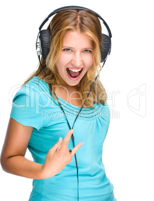 Beautiful girl with headphones show rock symbol isolated on white