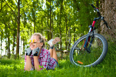 Young cyclist relaxation lying in the grass