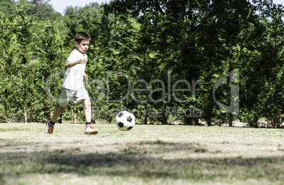 Child playing football in a stadium