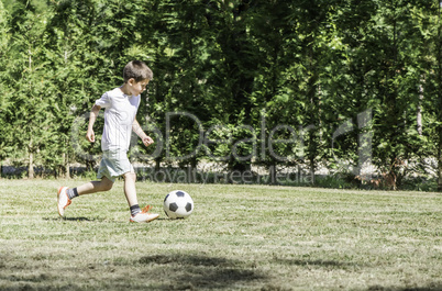 Child playing football in a stadium