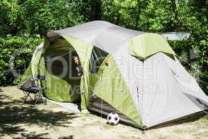 Child peeks from a tent