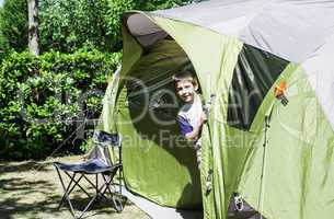 Child peeks from a tent