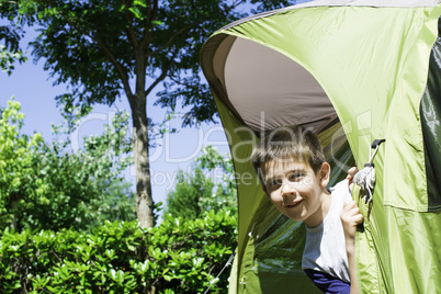 Child peeks from a tent