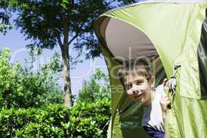 Child peeks from a tent