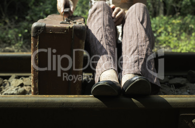 Woman and vintage suitcase on railway road