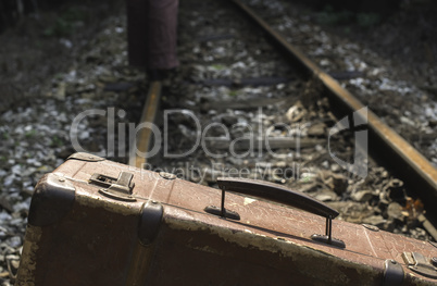 Woman and vintage suitcase on railway road