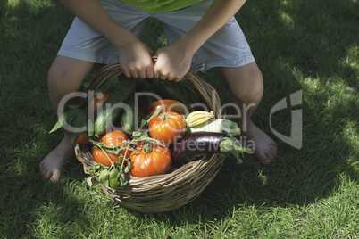 Child and basket with vegetables.