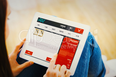 Composite image of teen using a tablet pc sitting on the floor