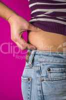 Woman with jeans shows her belly.