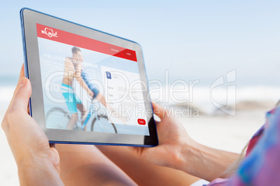 Composite image of woman sitting on beach in deck chair using ta