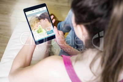 Composite image of woman using tablet at home