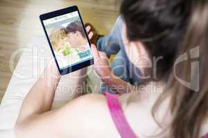 Composite image of woman using tablet at home