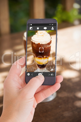 Composite image of female hand holding a smartphone