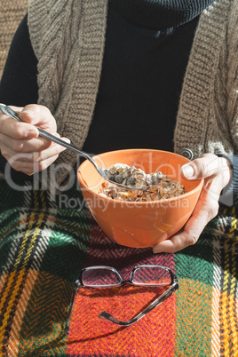 An elderly woman holding bowl