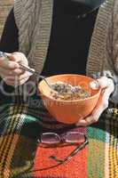 An elderly woman holding bowl