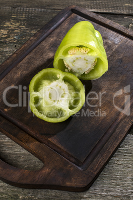 Cut green pepper on wood