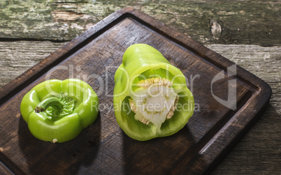 Cut green pepper on wood