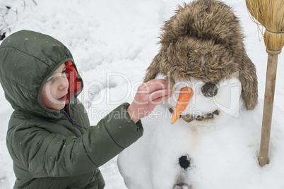 Snowman and child in the yard