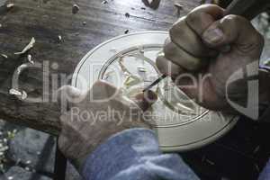 Hands of woodcarver make ??wooden bowl