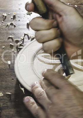 Hands of woodcarver make ??wooden bowl