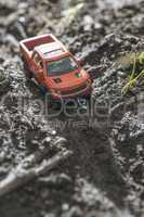 Small red off road car toy in the nature