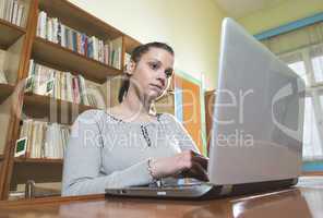 Student girl and laptop in a library