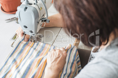 Women sew on sewing machine