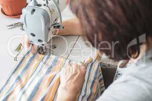 Women sew on sewing machine