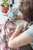 Women sew on sewing machine