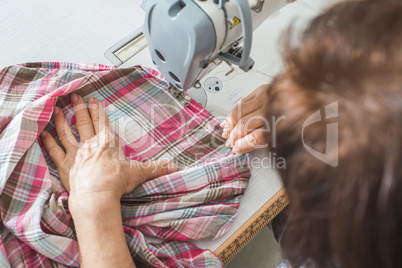 Women sew on sewing machine