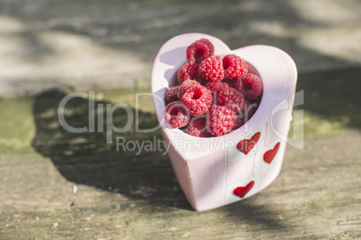 Raspberries in a bowl on wood