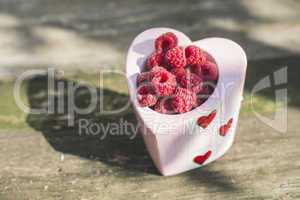 Raspberries in a bowl on wood