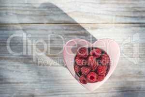 Raspberries in a bowl on wood