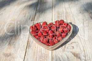 Raspberries in a bowl on wood