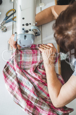 Women sew on sewing machine