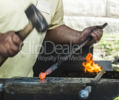 Blacksmith forges iron on anvil