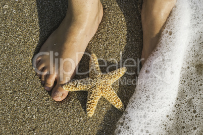 Starfish and feet on the beach Starfish and feet on the beach