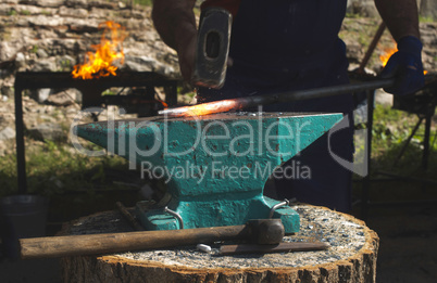 Blacksmith forges iron on anvil